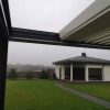 Tamsi bioklimatinė pergola su pravertu stogeliu