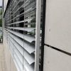 Fasadinės žaliuzės ant žemo pailgo lango iš arti kampu
