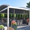Tradicinė balta pergola riestu stogu restorane su apšvietimu