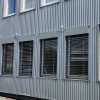 Lauko žaliuzės ant pastato vidutinio dydžio langų iš šono