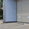 Užvertos fasadinės lauko žaliuzės ant aukšto plataus lango