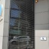 Atvertos fasadinės lauko žaliuzės ant aukšto pastato lango
