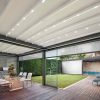 Šviesaus stogo pergola stumdomais stiklais lauko virtuvėje