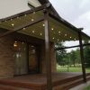 Kokybiška tamsi tentinė pergola prie namo sienos