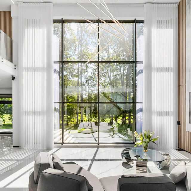 Baltos juostinės užuolaidos Baltos juostinės užuolaidos dengiančios didelius vitrinius langus svetainėje